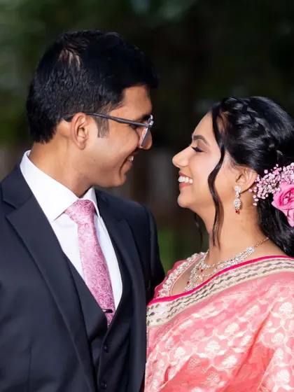 A romantic close-up of the couple. You can see the details of her soft eye makeup and the pretty pink flowers in her hair.