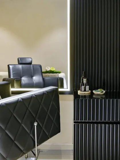 A closer look at the details of the cutting station. The diamond-patterned tufting on the leather chair complements the vertical lines of the black fluted cabinetry, creating a space that feels both luxurious and meticulously designed.