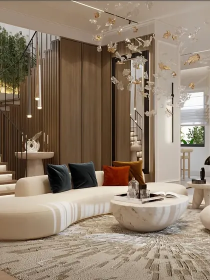 This design showcases a grand living space with a curved sofa and a stunning staircase. The use of marble, wood paneling, and a custom art-like chandelier creates an atmosphere of modern elegance and luxury.