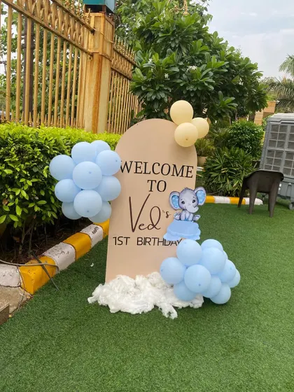 A personalized welcome sign for Ved's first birthday, featuring a cute elephant and matching balloons to greet guests as they arrive.