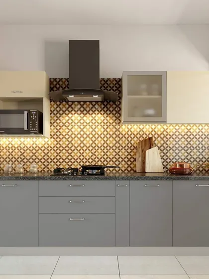A straight-line modular kitchen with grey base cabinets and cream wall units. The geometric backsplash is illuminated by LED strip lighting, creating a warm and inviting ambiance.