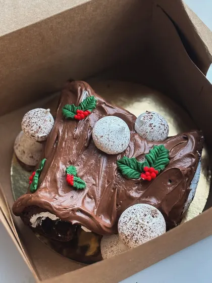 A close-up of the Yule log with its chocolate frosting, meringue mushrooms, and fondant holly.