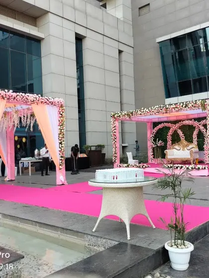 A view of the poolside wedding venue, showing the main stage and a separate, smaller mandap for other rituals.