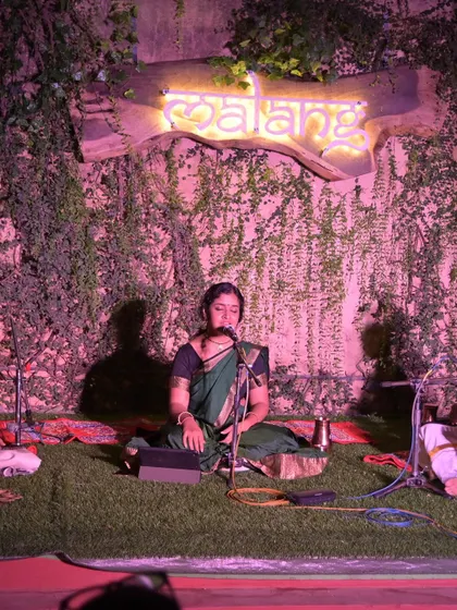 A performance at 'Malang' at Namma Ashram, with its beautiful green wall and neon sign creating a modern yet earthy ambiance for a classical concert.