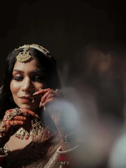 An artistic, through-the-glass shot of a bride getting ready.