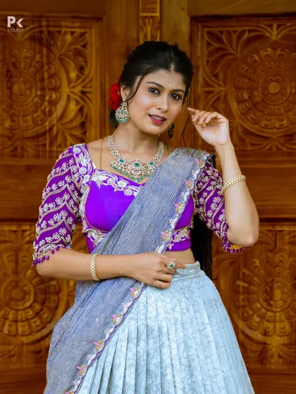 A close-up of the embroidered purple blouse, showing the intricate threadwork and the elegant neckline.
