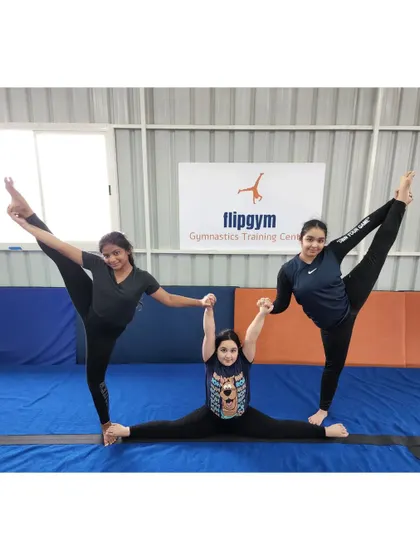 Teamwork makes the dream work. Here, three gymnasts create a beautiful pose combining splits and holds, showing both strength and flexibility.