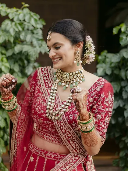 A happy, dancing bride. Her makeup is designed to be comfortable and long-lasting, allowing her to enjoy every moment of her Pheras.