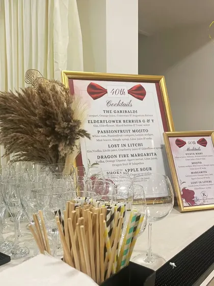 A stylish bar menu designed for a 40th birthday party. The elegant frame, custom cocktail names like "Lost in Litchi," and pampas grass decor all contribute to a chic and celebratory atmosphere.