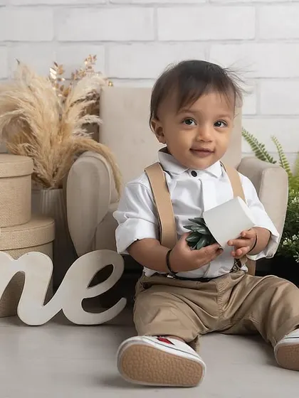 A handsome little gentleman celebrating his first birthday. This classic setup with neutral tones and natural elements is perfect for a timeless milestone portrait.