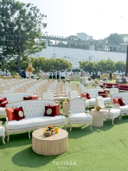 A mix of lounge and formal seating at a large outdoor wedding, with elegant white sofas providing a comfortable alternative to the ceremony chairs.