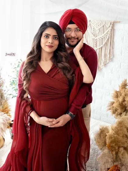 This lovely couple looks so elegant in coordinated deep red outfits. My boho setup with pampas grass and macrame provides a warm, natural backdrop for maternity portraits.