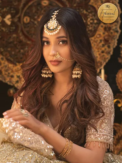 A direct and confident portrait from the same ethnic wear series, showcasing the full splendor of the bridal-style makeup and jewelry.