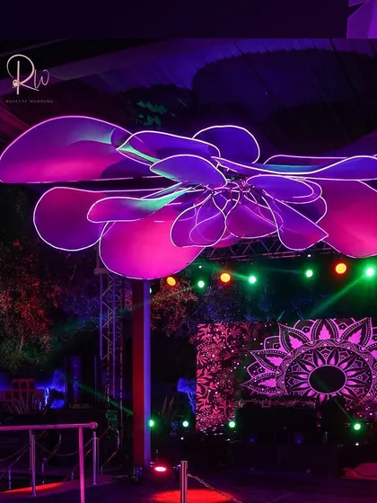 A massive, custom-made neon floral installation was suspended over the dance floor, bathing the space in a vibrant purple and pink glow and creating a high-energy focal point.