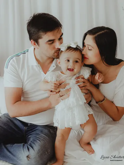 A sweet family moment filled with kisses for the happiest little girl. This photo radiates pure love and affection.