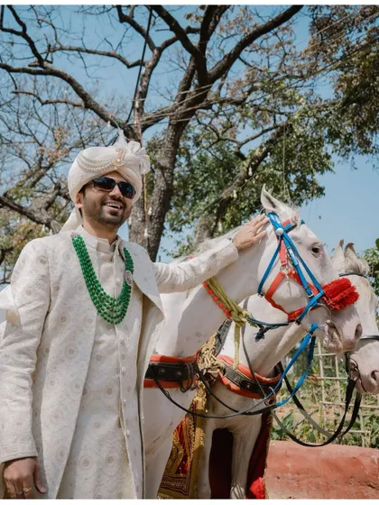 The groom arrives in style on a white horse for his Baraat, a classic and grand entrance for a North Indian wedding.