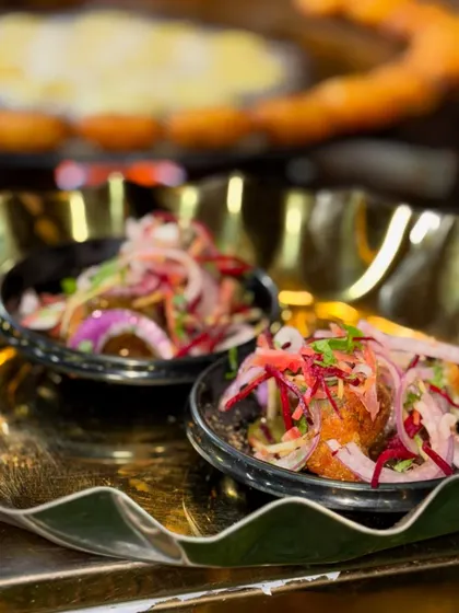 A plate of my Delhi-style Karari Aloo Tikki Chaat, loaded with onions, beets, and spices. It's a crunchy, tangy, and savory explosion of flavors in every bite.