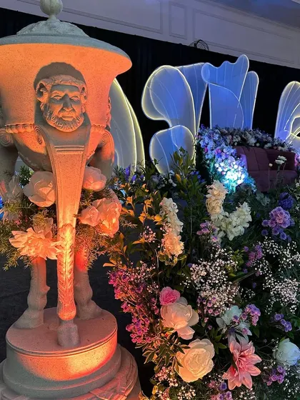 A detail shot of the modern reception decor, showing the blend of classic statuary with contemporary lighting and floral design.