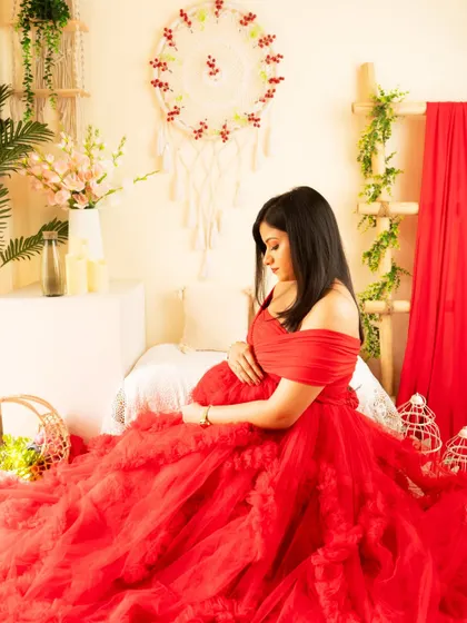 A quiet moment of reflection in a bold red gown. The boho setup is styled with red accents to complement the dress.