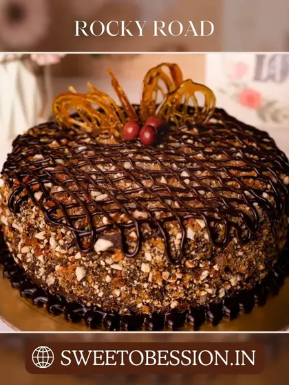 A crunchy and decadent Rocky Road cake, loaded with nuts and drizzled with chocolate.