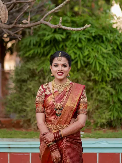 A classic bridal portrait. The makeup is timeless, and her hair is styled in a neat bun, ready for the wedding ceremony.