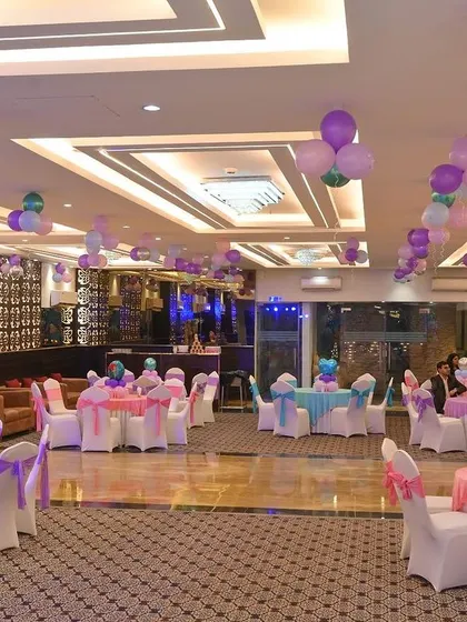 Guest seating arrangement for a large party. We ensure that the table linens, chair covers, and balloon decorations all match the event's color scheme.