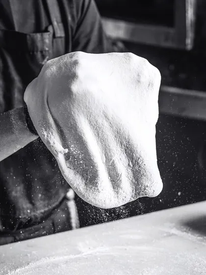 A playful dance of flour, fun, and fantastic flavors. Tossing the dough is a skill that takes practice, and it's mesmerizing to watch.