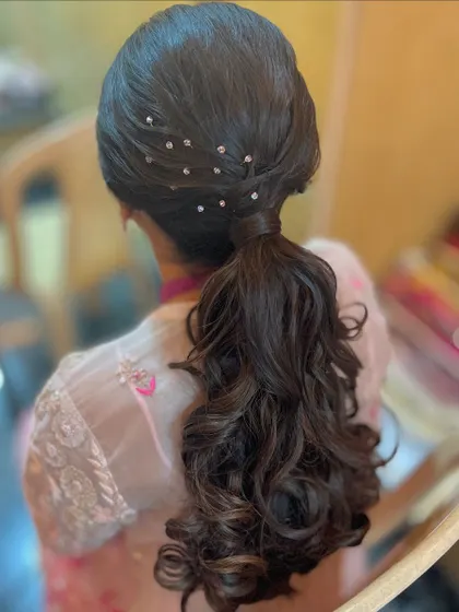 A curly ponytail with a sprinkle of delicate crystal accessories, perfect for a party look.