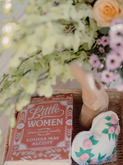 A copy of "Little Women" and other curated props that add a personal and literary touch to the decor.