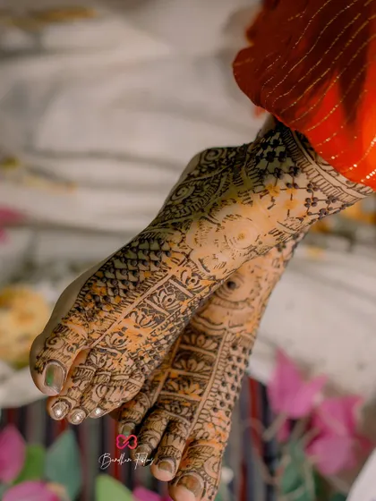 A detailed shot of the bride's feet, adorned with intricate Mehendi designs, a beautiful part of the pre-wedding rituals.