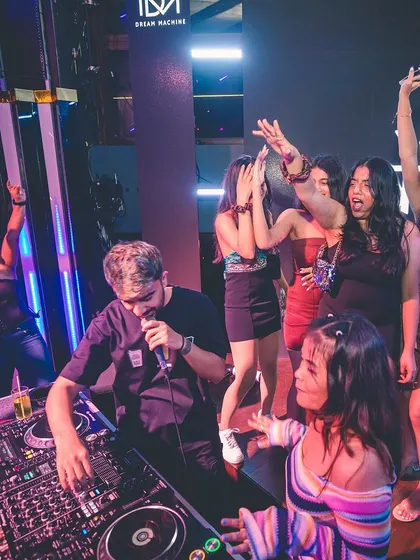 On the mic, interacting with the partygoers right next to the booth. I break the barrier between the stage and the dance floor.