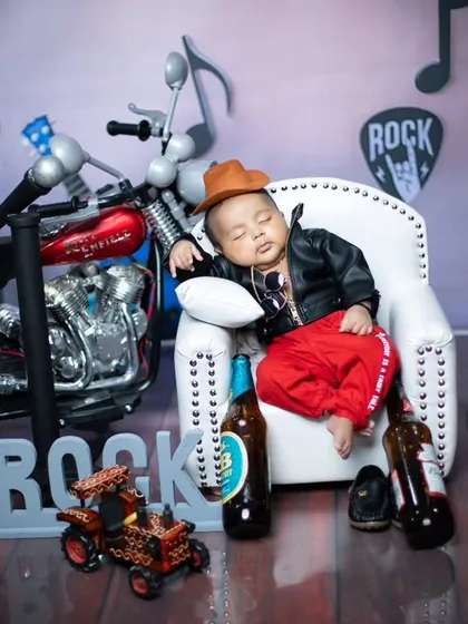 Another angle of our little rockstar, showing off the full setup with a miniature motorcycle and 'ROCK' sign. I pay attention to every detail to make the concept feel complete and fun.
