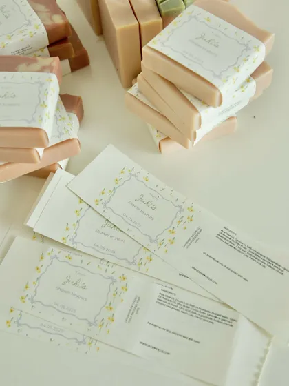 The process of creating the custom labels for the Amsterdam baby shower favors, with the finished soaps in the background.