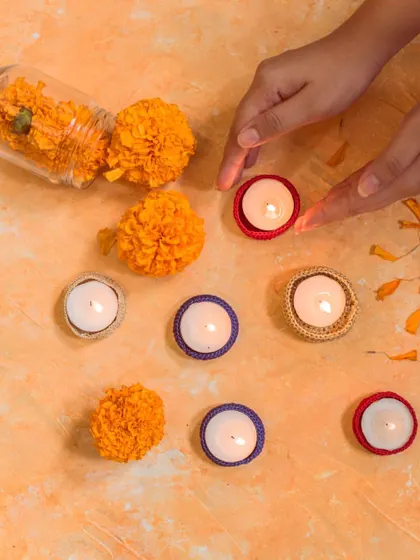 An overhead view showing how our colorful crochet diya jackets can be arranged with marigold flowers for a traditional yet unique festive display. Each piece is handcrafted with care.