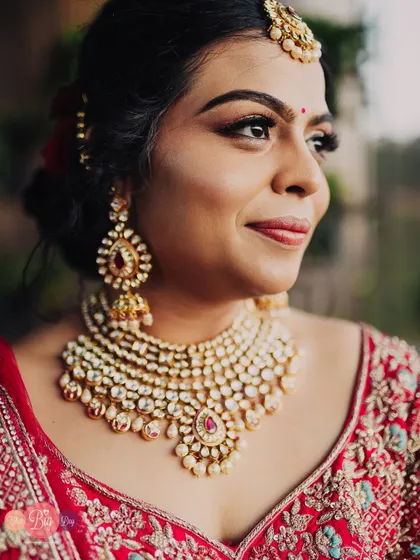 A stunning close-up portrait of the bride, Rucha, showcasing her flawless makeup and magnificent Polki jewelry.