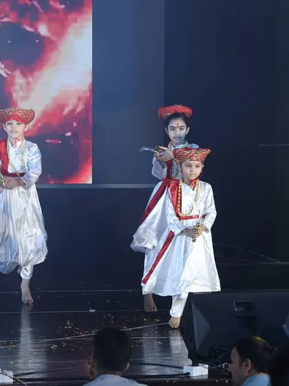 A close-up of the young performers in the Tanaji act, showing their detailed costumes and focused expressions.