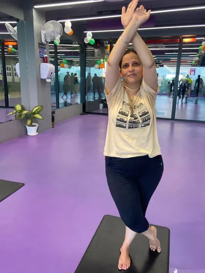 A member demonstrates a variation of the Eagle Pose with arms raised, a modification we teach to accommodate different levels of shoulder flexibility.