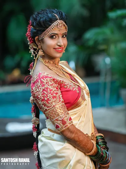 A beautiful three-quarter portrait of a South Indian bride, showcasing her traditional saree and braided hairstyle.