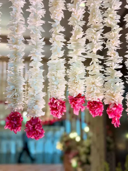 Another detail shot of the delicate white and pink floral strings used in the entrance canopy. This kind of dense floral work is perfect for creating a high-impact, luxurious atmosphere for a wedding or reception.