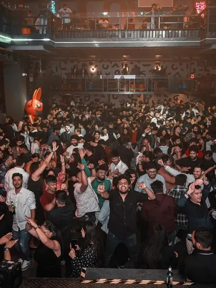 The entire crowd at the corporate event, hands in the air.