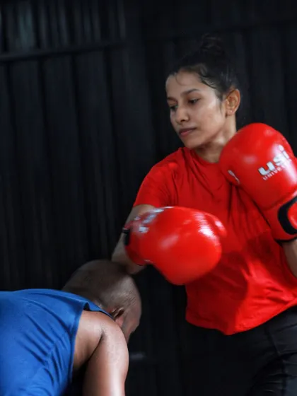 A female boxer showing great form on a follow through punch. Power comes from the whole body.
