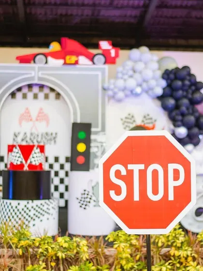 "Thanks for racing by!" A stop sign prop adds a fun, thematic detail to this action-packed race car party. Every element is designed to immerse guests in the world of racing.