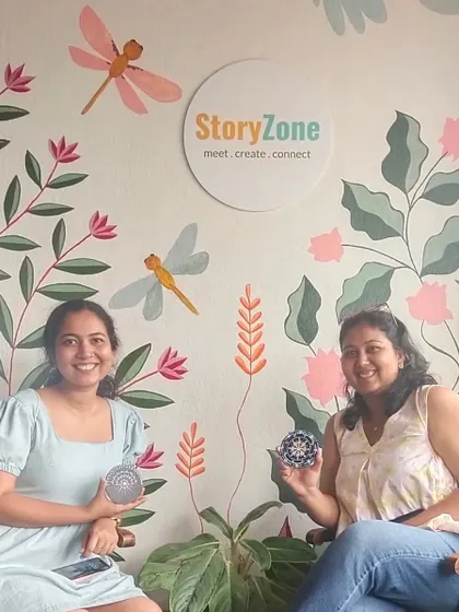 Two friends posing in front of our signature studio wall after a fun and creative session.