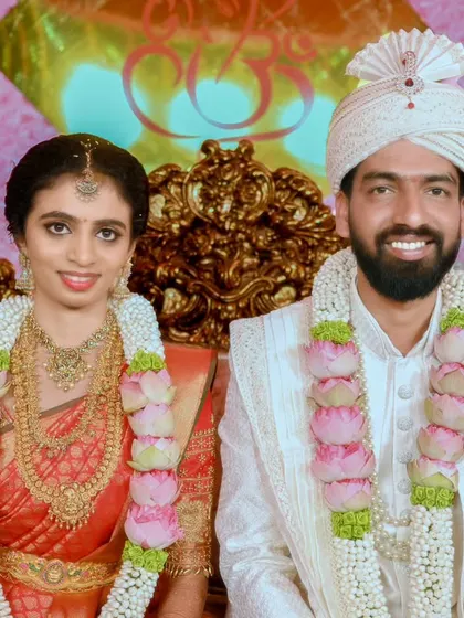 A formal portrait of the couple seated on the wedding throne, looking directly at the camera, a timeless keepsake for the family.