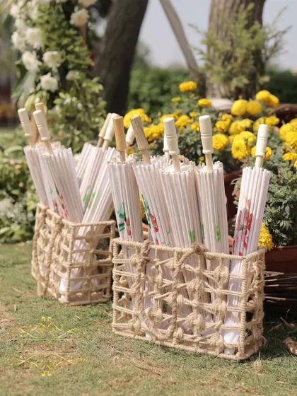 Baskets of beautiful white paper umbrellas, a thoughtful and practical detail for a sunny outdoor wedding.