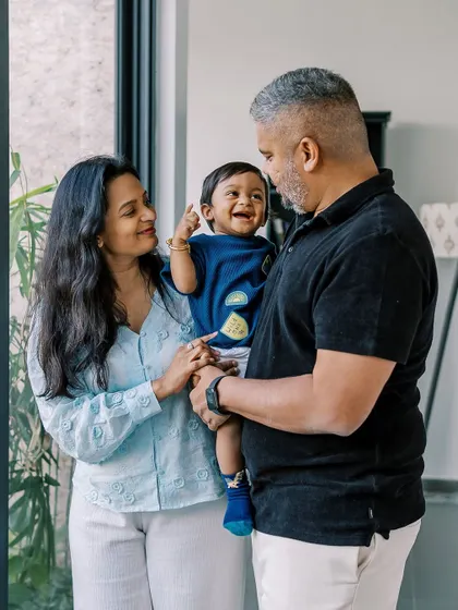 A happy family moment during an indoor birthday shoot. The baby's smile says it all. These are the memories that will be treasured for a lifetime.