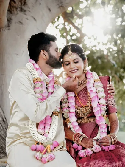 A tender moment between the newly married couple, seated under a tree after their ceremony in Palladam.