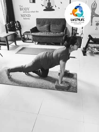 A client practices a modified plank on her knees with hands on blocks, a great way to build upper body strength progressively.