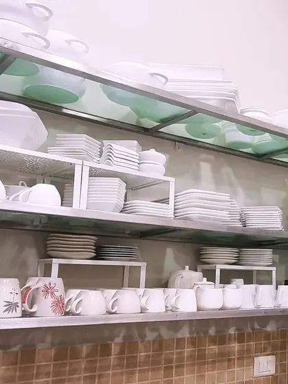 I love using shelf risers, especially for open steel racks in a commercial or large-scale kitchen. They instantly double the usable storage space for crockery.