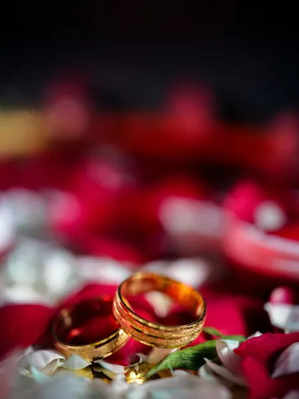 An artistic close-up of the engagement rings nestled among flower petals.
